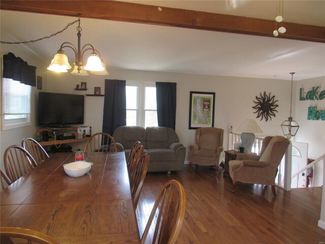 dining room with a chandelier, beam ceiling, and wood finished floors