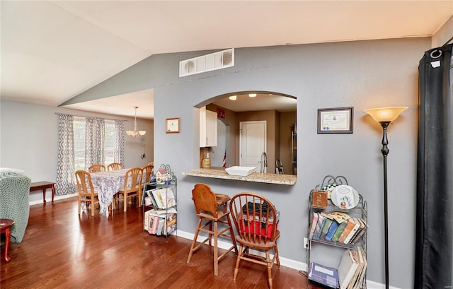 dining space featuring arched walkways, dark wood-type flooring, visible vents, and baseboards