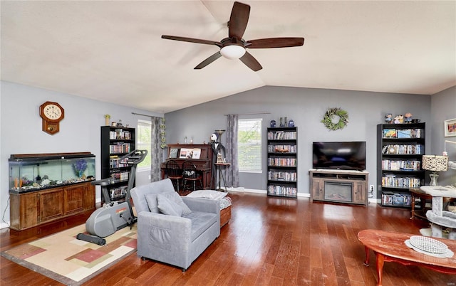 living room with baseboards, a ceiling fan, vaulted ceiling, and hardwood / wood-style flooring