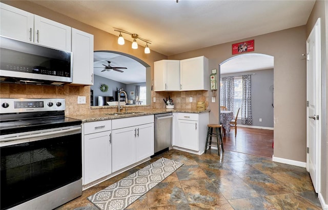 kitchen with appliances with stainless steel finishes, ceiling fan, a sink, and a healthy amount of sunlight