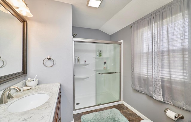 bathroom featuring vanity, baseboards, a stall shower, tile patterned floors, and lofted ceiling