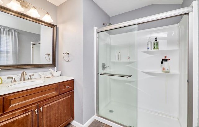full bath with a shower stall, vanity, and baseboards