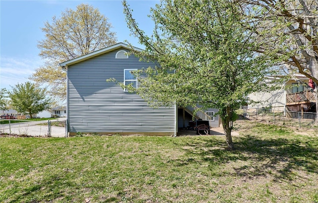 view of side of home with a yard and fence