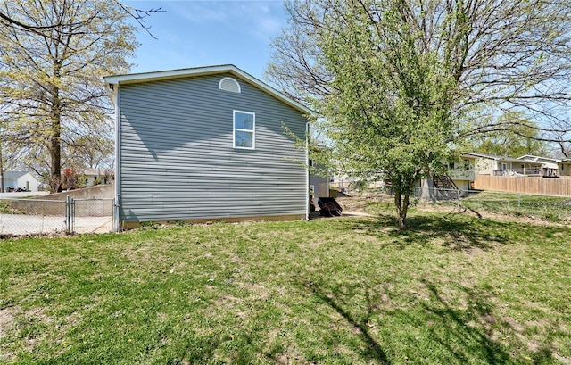 view of home's exterior featuring fence and a lawn