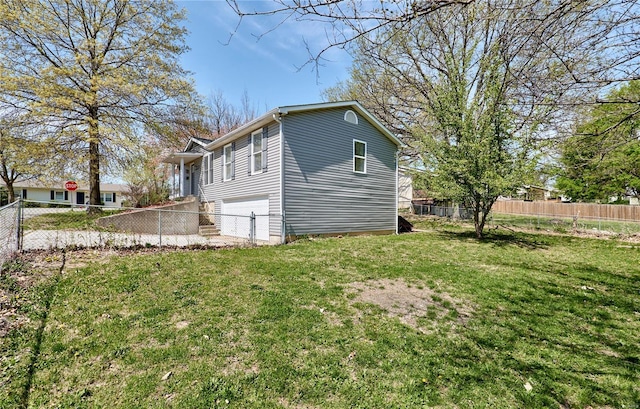 view of side of home featuring fence, a lawn, and a garage