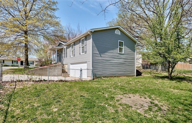 view of home's exterior with a yard, fence, and a garage