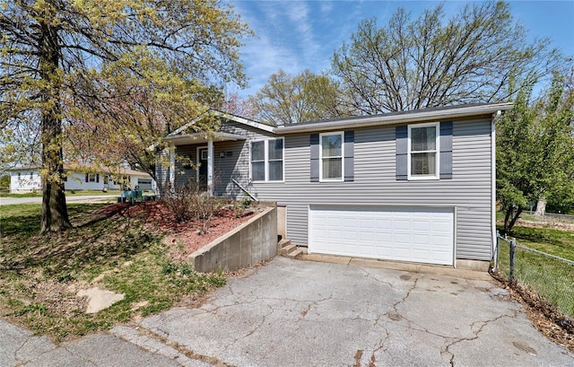 view of front of property featuring a garage, driveway, and fence