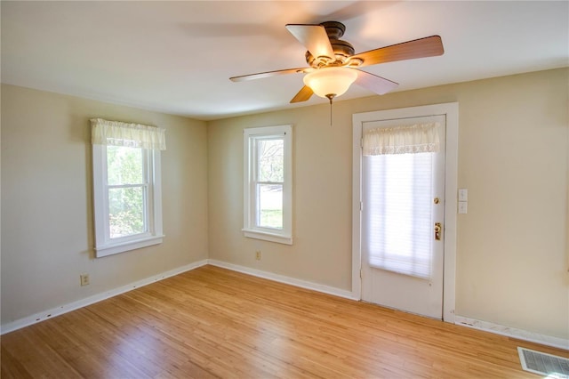 unfurnished room with light wood-type flooring, baseboards, and a healthy amount of sunlight