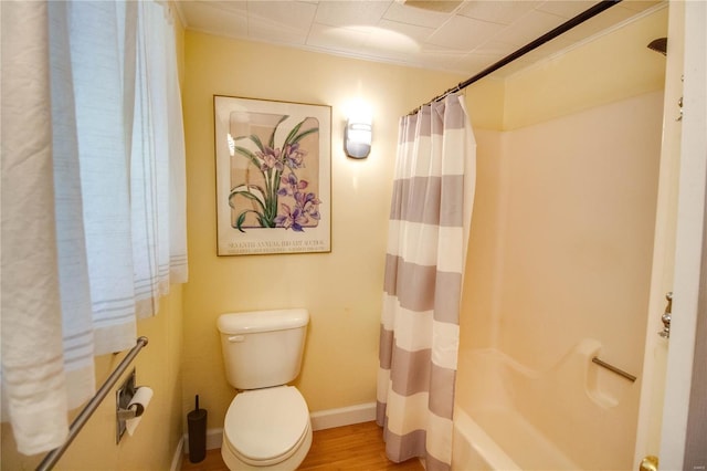 full bath with baseboards, wood finished floors, and toilet
