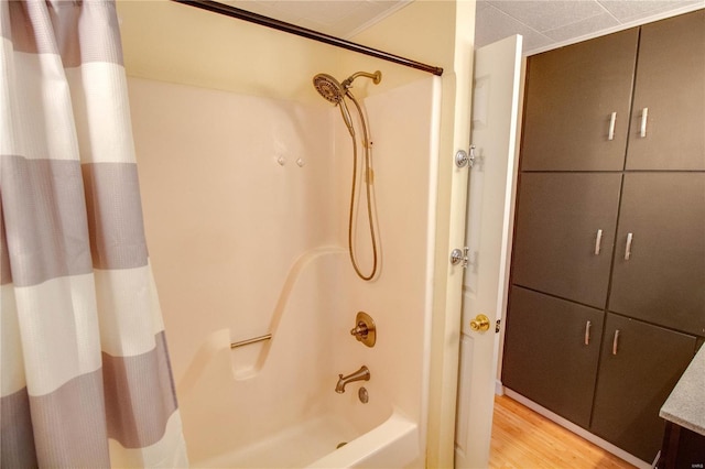 full bathroom with wood finished floors and shower / bathtub combination with curtain