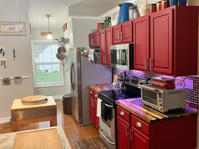 kitchen featuring decorative backsplash, a toaster, dark brown cabinets, butcher block countertops, and appliances with stainless steel finishes