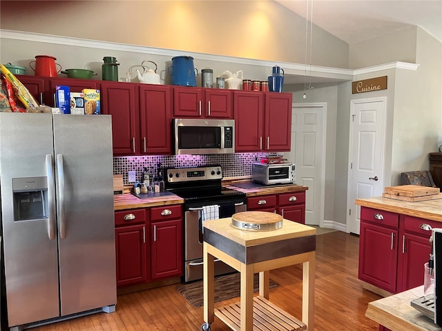 kitchen with dark brown cabinets, appliances with stainless steel finishes, light wood-style flooring, decorative backsplash, and a toaster