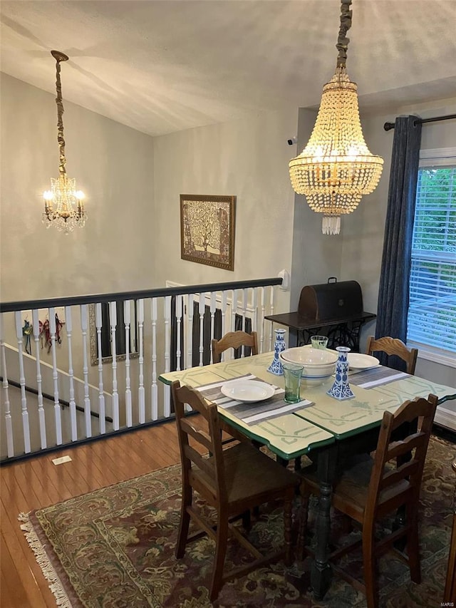 dining space with hardwood / wood-style floors and a chandelier