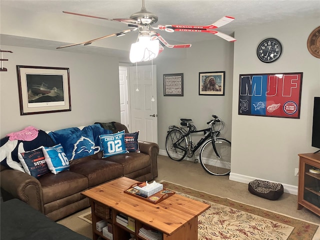 carpeted living room featuring baseboards and ceiling fan