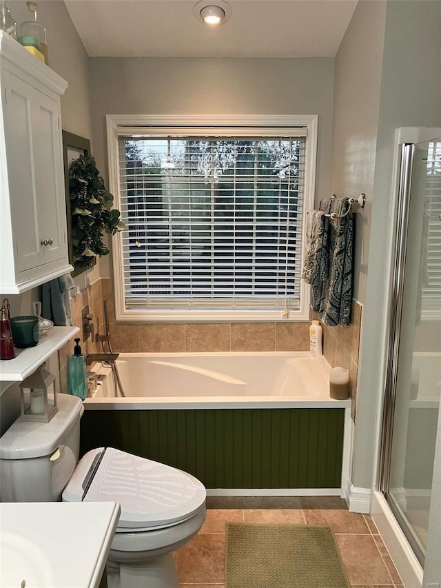 full bath with a garden tub, tile patterned flooring, toilet, and a shower stall