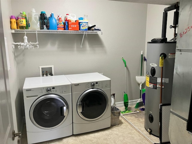 clothes washing area with laundry area, washer and clothes dryer, and water heater