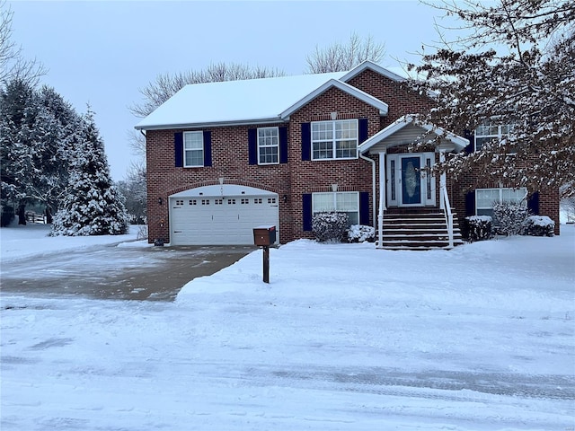 view of front of house with brick siding, a garage, and aphalt driveway