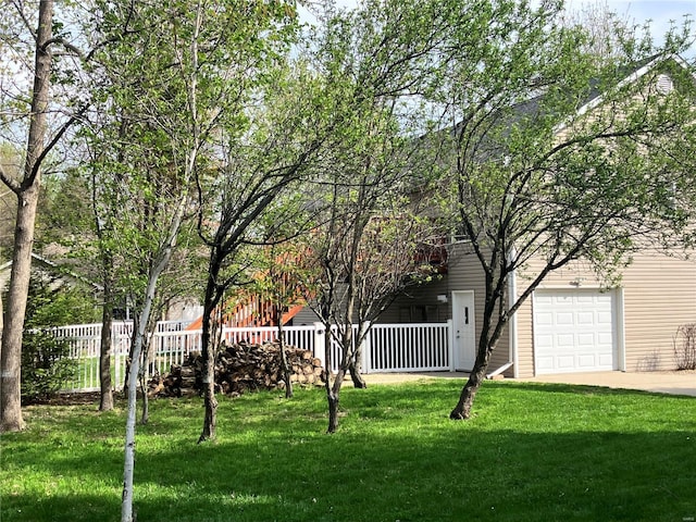 view of yard featuring fence and concrete driveway