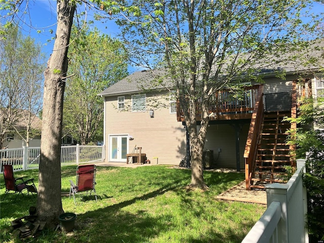 back of house with french doors, a wooden deck, fence, a yard, and stairs