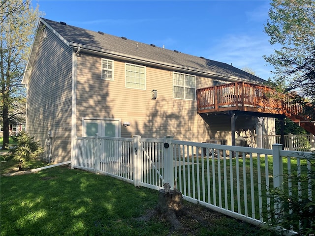 back of house with a yard, fence, and a wooden deck