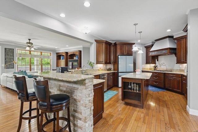 kitchen with open shelves, appliances with stainless steel finishes, custom exhaust hood, and light wood-style flooring