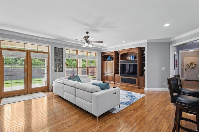 living area featuring crown molding, ceiling fan, light wood-style floors, french doors, and recessed lighting