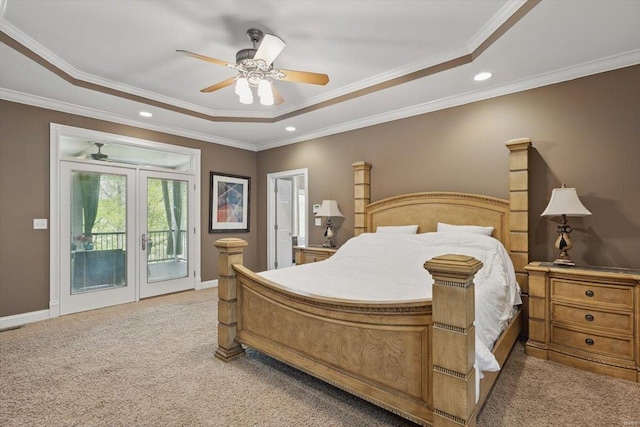 bedroom featuring recessed lighting, a tray ceiling, light colored carpet, and access to exterior