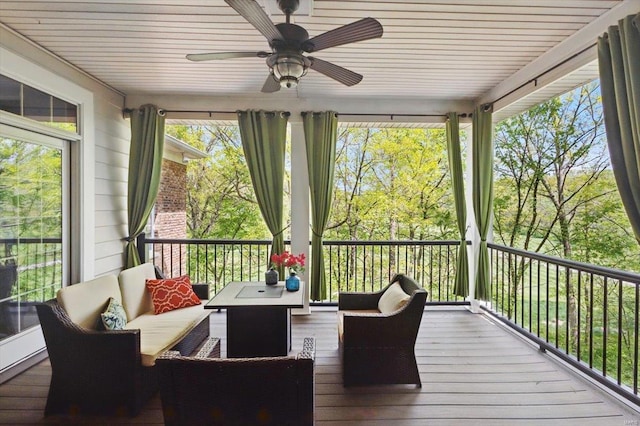 sunroom with a ceiling fan, an outdoor living space, and hardwood / wood-style flooring