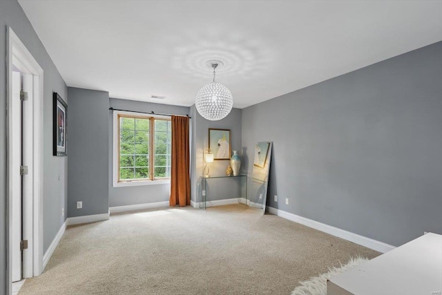 unfurnished bedroom with baseboards, a chandelier, light carpet, and visible vents