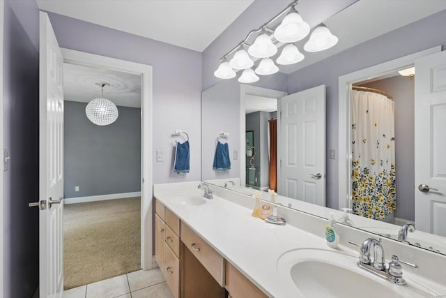 bathroom with a sink, tile patterned floors, baseboards, and double vanity