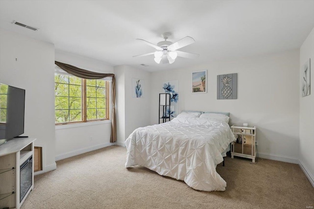 carpeted bedroom featuring baseboards, ceiling fan, and visible vents