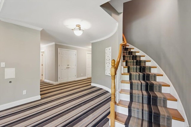 stairway with carpet floors, ornamental molding, and baseboards