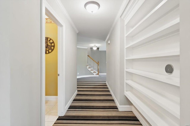 hall featuring tile patterned flooring, carpet, baseboards, ornamental molding, and stairway