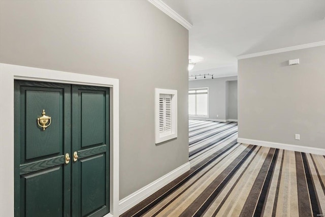 carpeted entryway with baseboards and ornamental molding