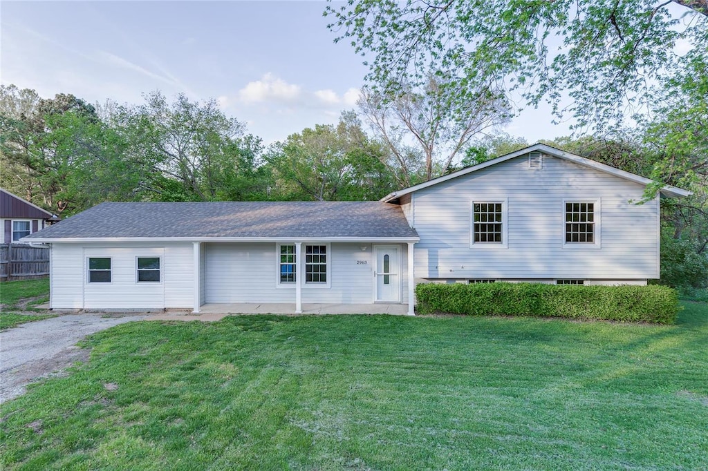view of front of property featuring a shingled roof and a front yard