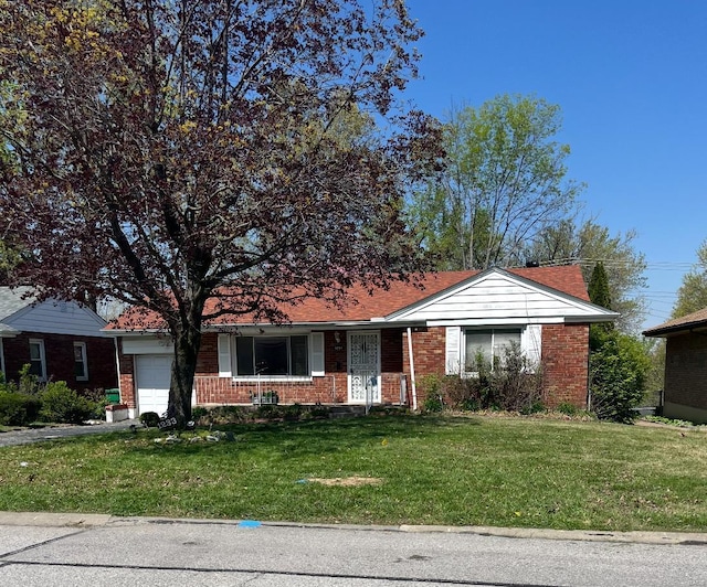 single story home featuring an attached garage, brick siding, and a front yard