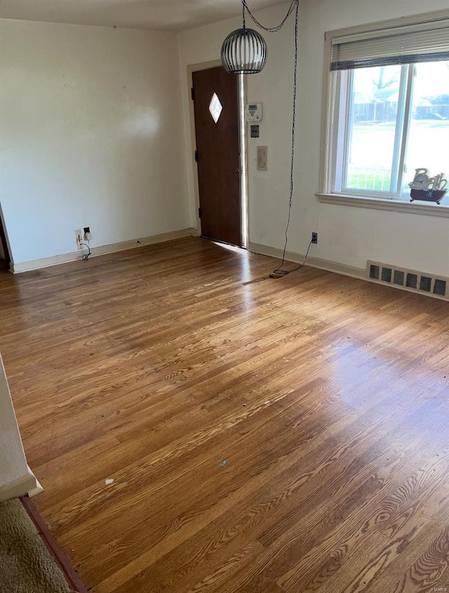 entrance foyer featuring wood finished floors, visible vents, and baseboards
