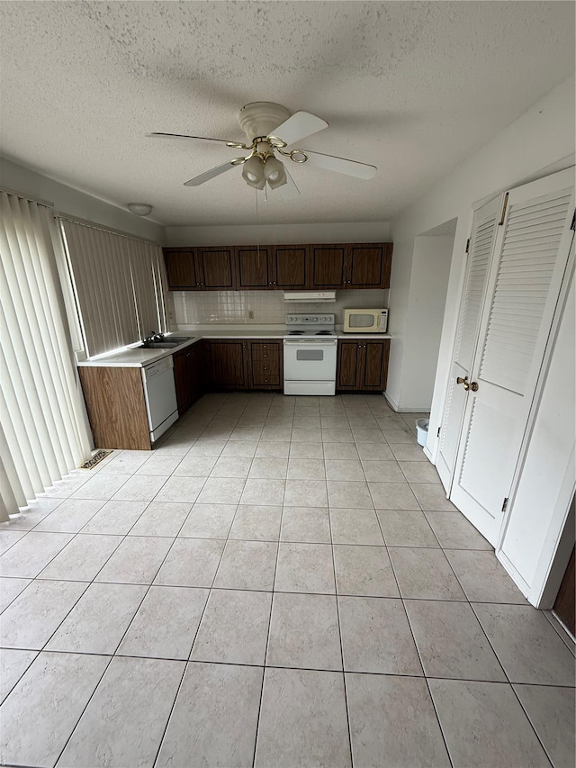 kitchen with light countertops, a ceiling fan, light tile patterned floors, white appliances, and a textured ceiling