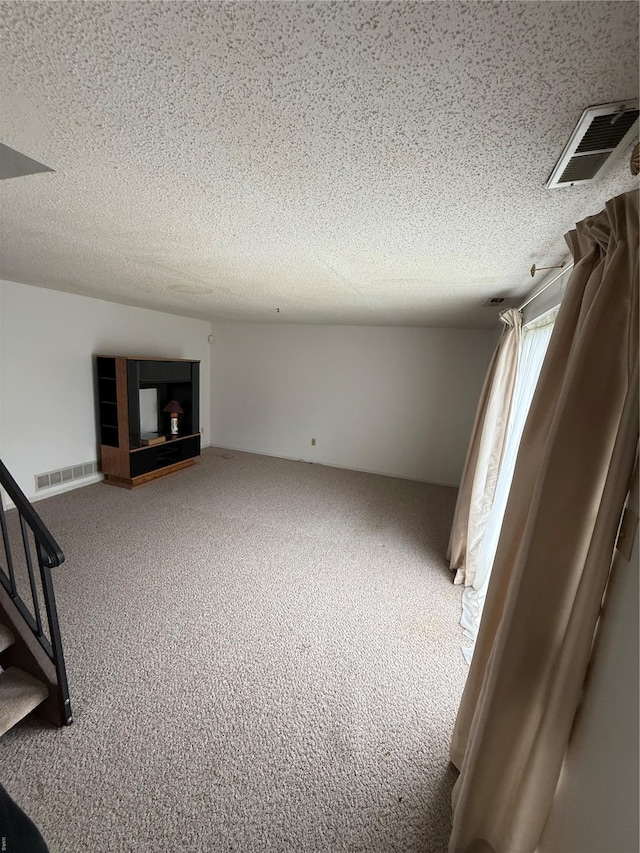 interior space with visible vents, a textured ceiling, and stairs