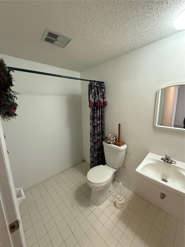 bathroom with tile patterned floors, a textured ceiling, toilet, a shower with shower curtain, and visible vents