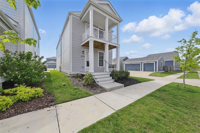 view of front of house with covered porch, driveway, a front yard, an outdoor structure, and a balcony