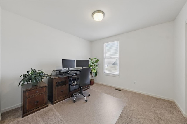 office with baseboards, visible vents, and light carpet