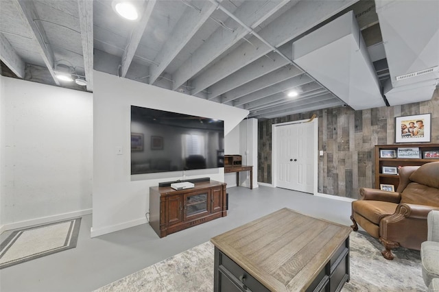 living area with baseboards and finished concrete floors