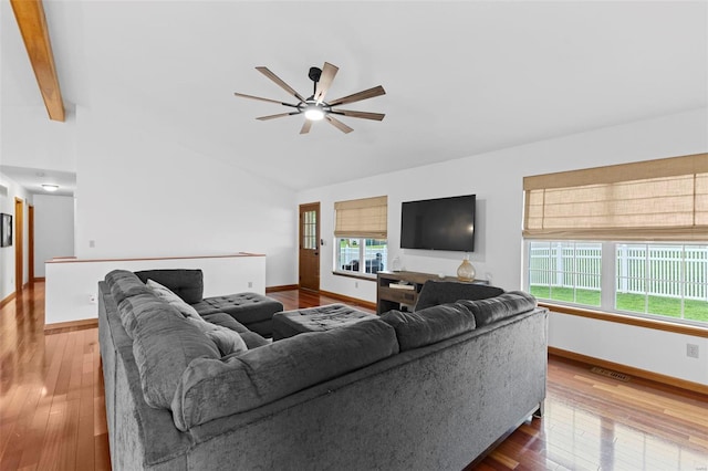 living room featuring lofted ceiling, baseboards, hardwood / wood-style floors, and a ceiling fan