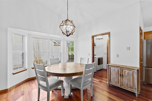 dining area with a chandelier, separate washer and dryer, dark wood-style floors, and baseboards
