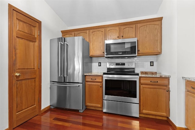 kitchen featuring stainless steel appliances, dark wood-style floors, backsplash, light stone counters, and brown cabinetry
