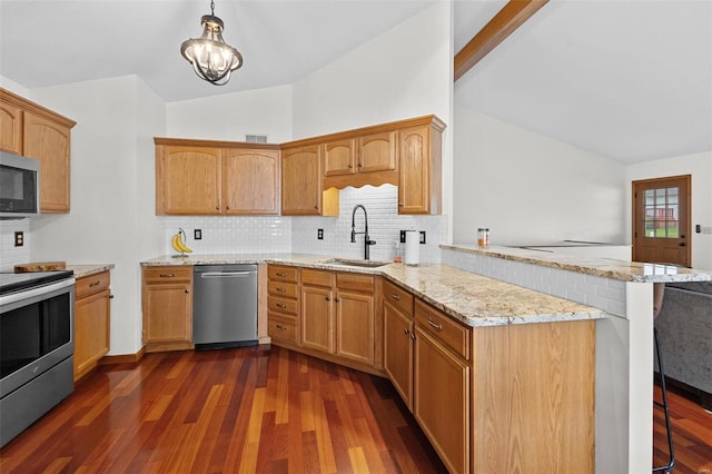 kitchen featuring a sink, stainless steel appliances, a peninsula, lofted ceiling, and dark wood-style flooring