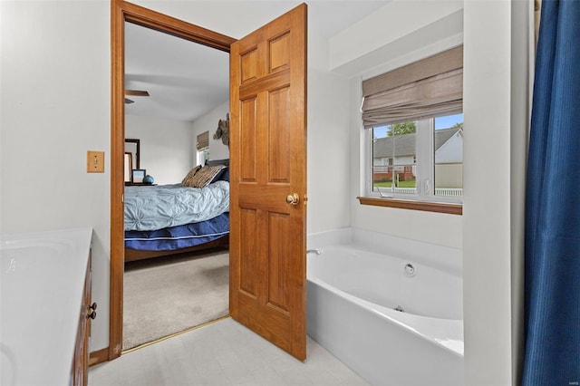 bathroom with connected bathroom, a garden tub, tile patterned floors, and a sink