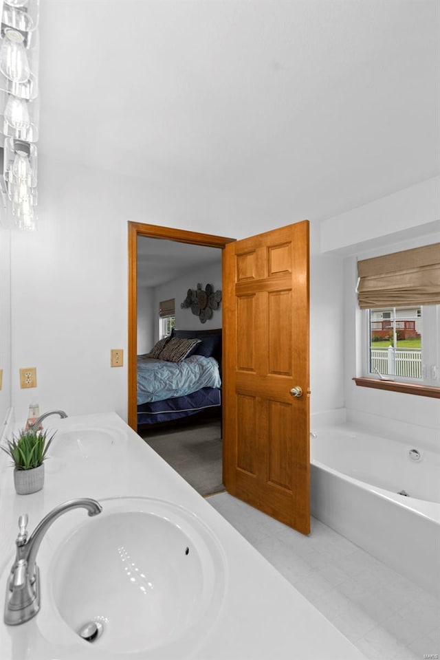 ensuite bathroom featuring a bath and double vanity