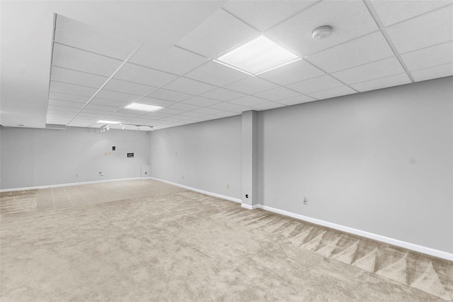 finished basement with carpet floors, a drop ceiling, and baseboards